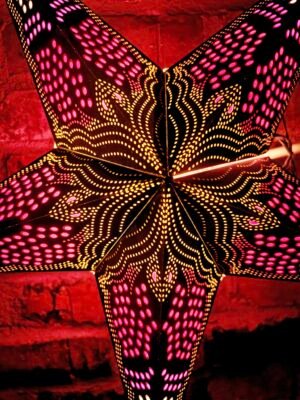 Hängande julstjärna i papper, adventsstjärna för fönster med dekorativt mönster.