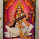 Saraswati tavla med hinduisk gudinna sittande med veena och heliga skrifter