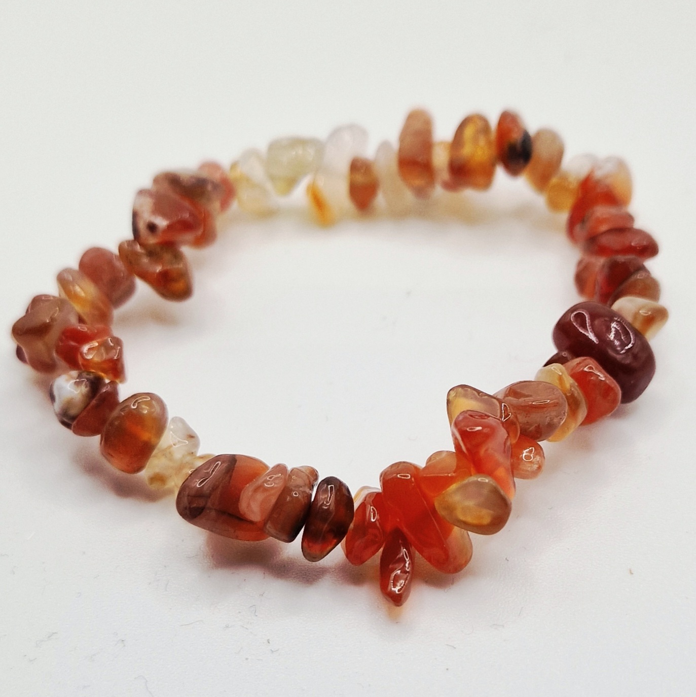 Kristallarmband chipsarmband Karneol Chipsarmband med små, oregelbundna stenar av blandade kristalltyper trädda på elastisk tråd.