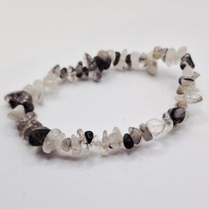 Chipsarmband med små, oregelbundna stenar av blandade kristalltyper trädda på elastisk tråd.