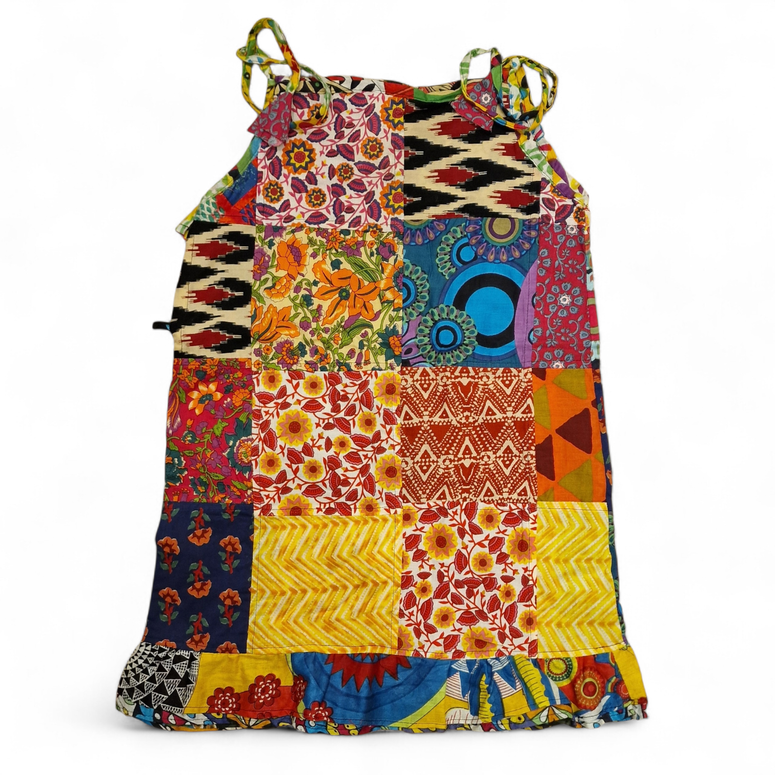 ärgglad barnklänning i unik patchwork-design, tillverkad av återvunnen bomull. Mjuk, bekväm och ett hållbart val för barn.