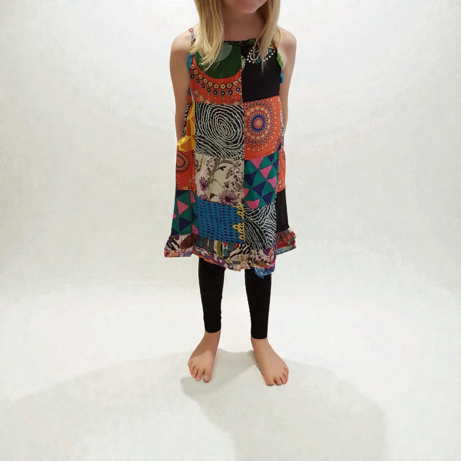 ärgglad barnklänning i unik patchwork-design, tillverkad av återvunnen bomull. Mjuk, bekväm och ett hållbart val för barn.